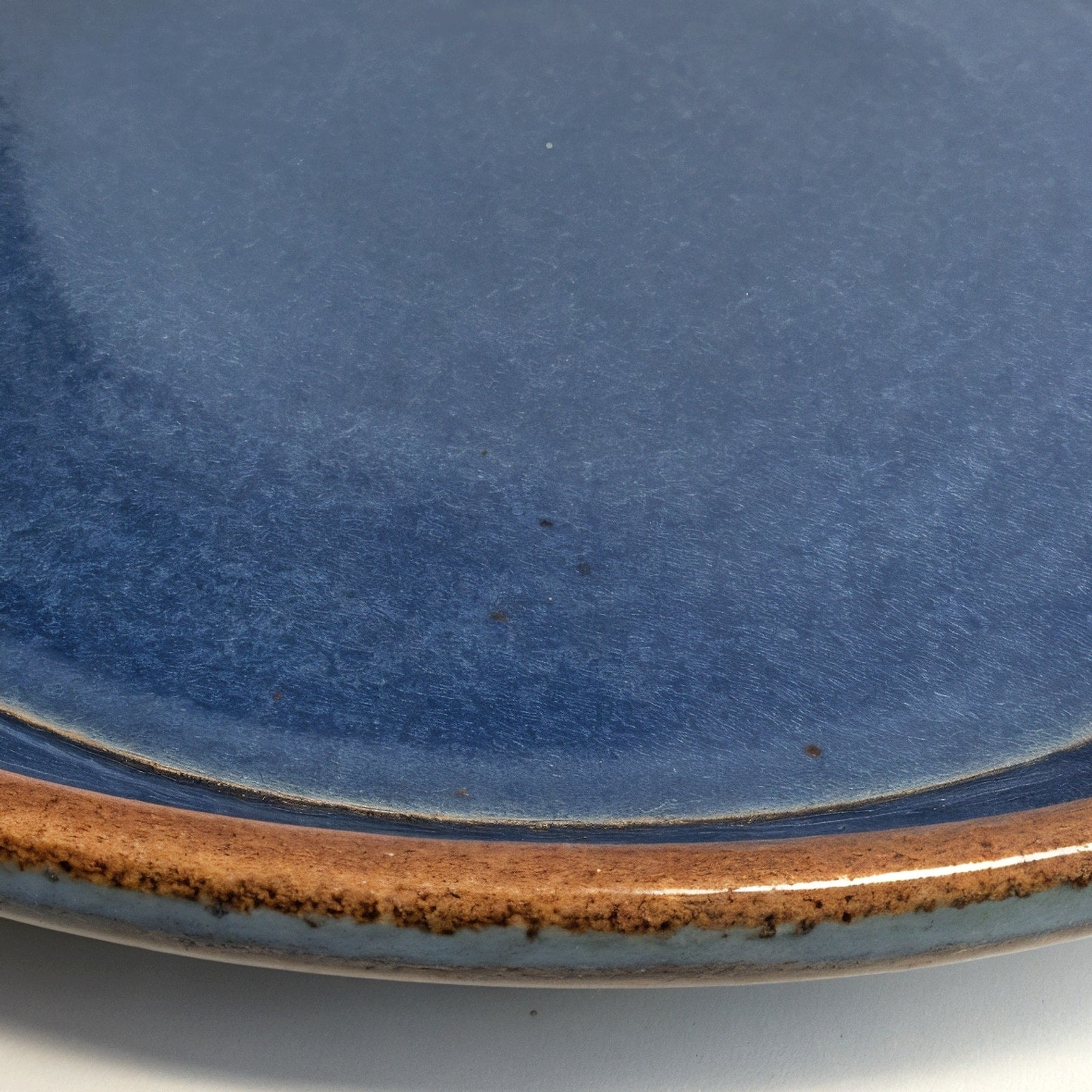 Remoxila Midnight Blue Plate — macro rim detail showing raised rim and glaze pooling