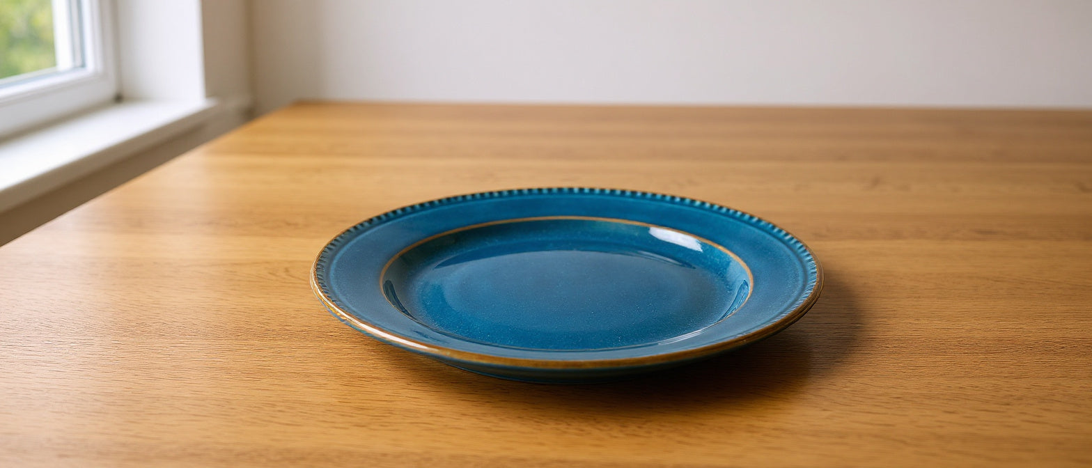 Remoxila Deep Ocean stoneware plate on an oak dining table in soft morning light