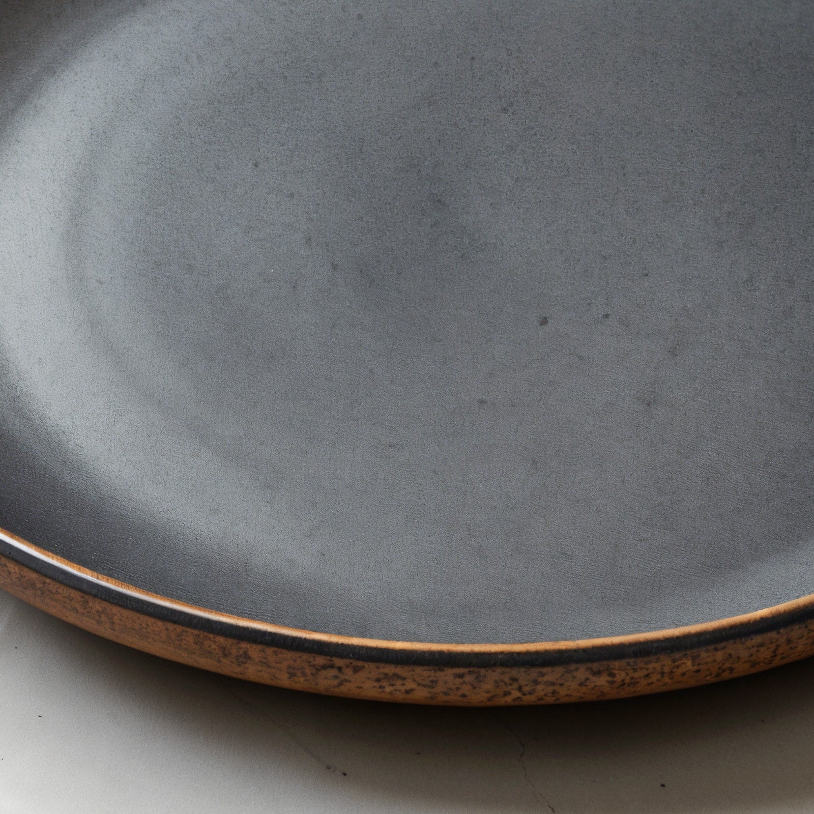 Remoxila Charcoal Black Stoneware Plate — macro close-up of the raised rim and glaze pooling